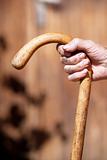 hand of an old peasant woman holding a walking stick