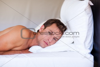 Attractive man relaxing on bed