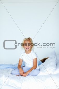 Little girl sitting in bed with copyspace 