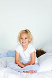 Little girl sitting in bed with copyspace