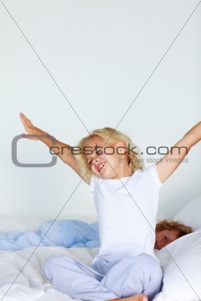Little girl stretching in bed