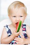 Cute little girl eating a watermelon.