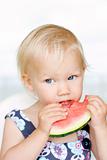 Cute little girl eating a watermelon.