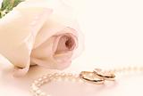 Wedding rings, pearl beads and rose