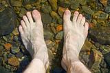 bare feet on shoal of lake