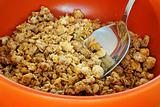 cereals with spoon in orange bowl