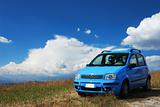 Bright pale blue modern car with beautiful nature background                               