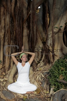 Woman meditating in front of Bodhi Tree roots