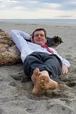 Businessman sleeping on a beach
