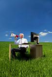 Business Concept Man Using Megaphone In A Green Field