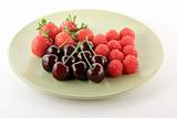 Red fruits on light plate