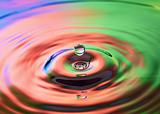 Colorful water drop falling into water