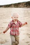 A happy little boy at the beach.