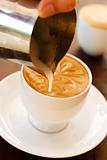 A barista creating latte coffee art.