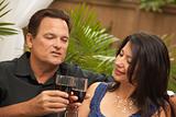 Attractive Hispanic and Caucasian Couple Drinking Wine Outside.
