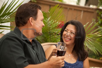 Attractive Hispanic and Caucasian Couple Drinking Wine Outside.