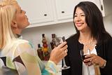 Two Girlfriends Enjoy a Glass of Wine in the Kitchen.