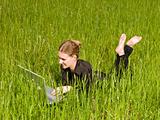 Woman with a computer in the grass