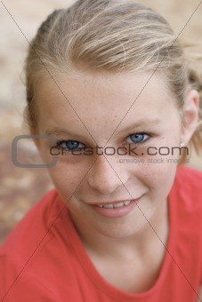 Close-up portrait of a pretty, blonde haired teenage girl outdoors.