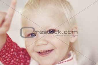 Portrait of a smiling and laughing toddler pointing.