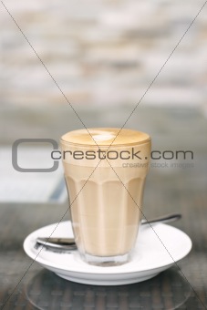 Latte in a glass on a café table.