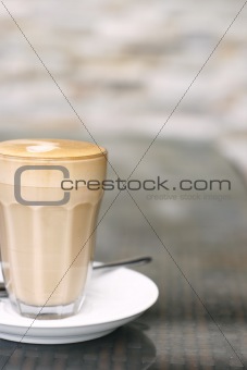 Latte in a glass on a café table.