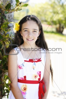 Portrait of a pretty, dark haired young girl outdoors.