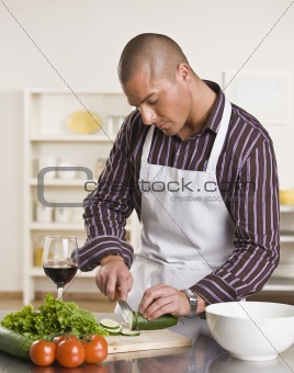 Attractive male cutting salad