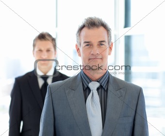 Senior and young businessmen looking to the camera