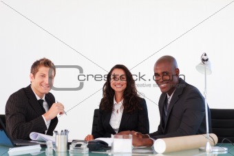 Business people smiling to the camera in a meeting