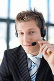Young businessman with a headset on in a call center