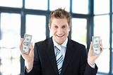 Smiling businessman holding dollars
