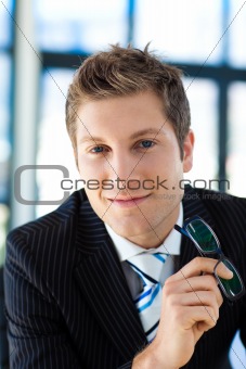 Businessman smiling at the camera holding glasses