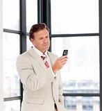 Portrait of a businessman sending a text on a mobile-phone