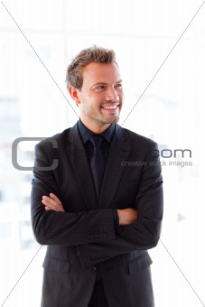 Smiling young businessman with folded arms