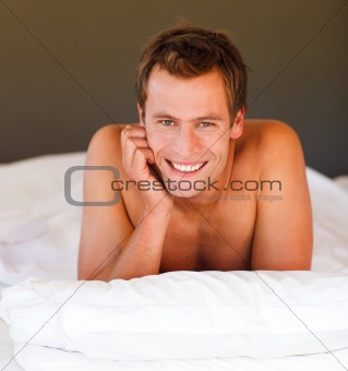 Attractive smiling youn boy in bed