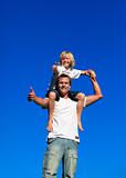 Kid on man's shoulders with thumbs up