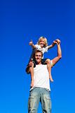Son on his father's shoulders with thumbs up