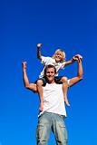 Strong child sitting on his father's shoulders
