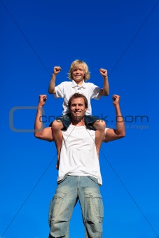 Strong son sitting on his father's shoulders