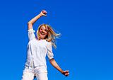 Smiling woman jumping against blue sky