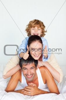 Parents and son playing in bed