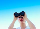 Businesswoman looking through binoculars