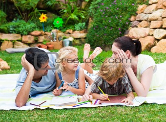 Happy family drawing in a park