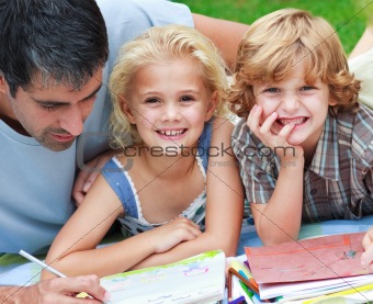 Smiling children drawing with their father