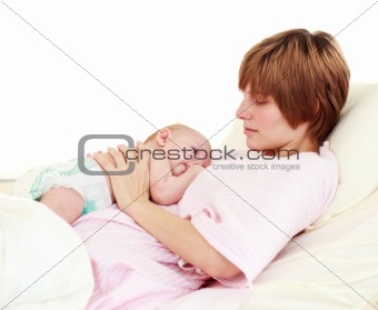 Patient looking at her newborn baby in bed