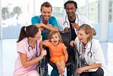 Doctors playing with a baby in a wheelchair