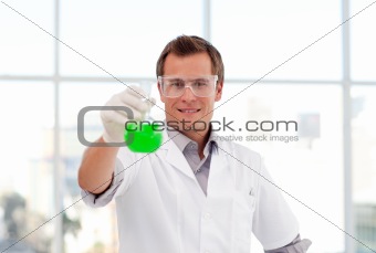 Smiling scientist examining a test-tube