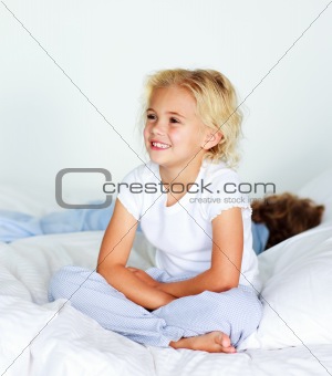 Little girl sitting on bed before sleeping