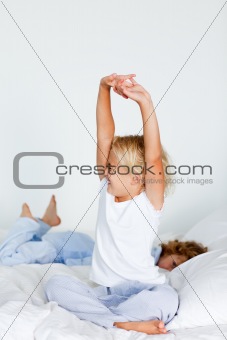 Blonde girl stretching in bed
